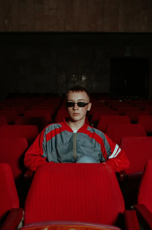 a man in shades with his face hidden by a red chair