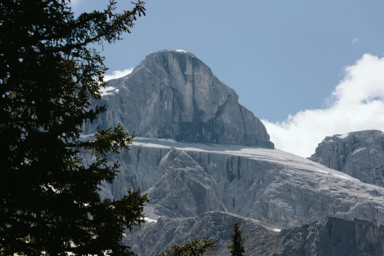 tall mountain surrounded by trees against a blue sky