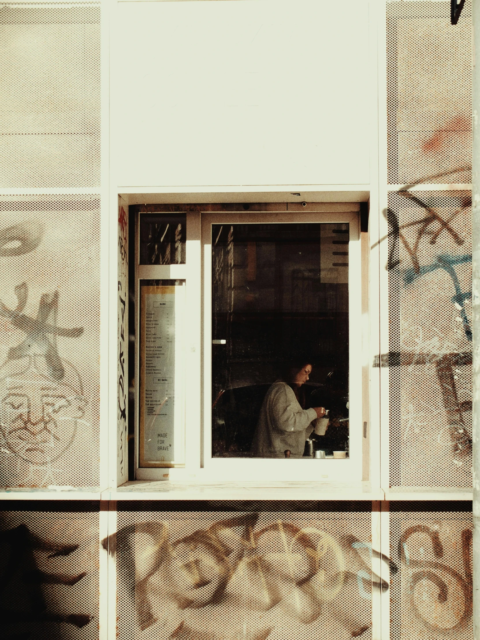 a person sitting on a bench outside a window