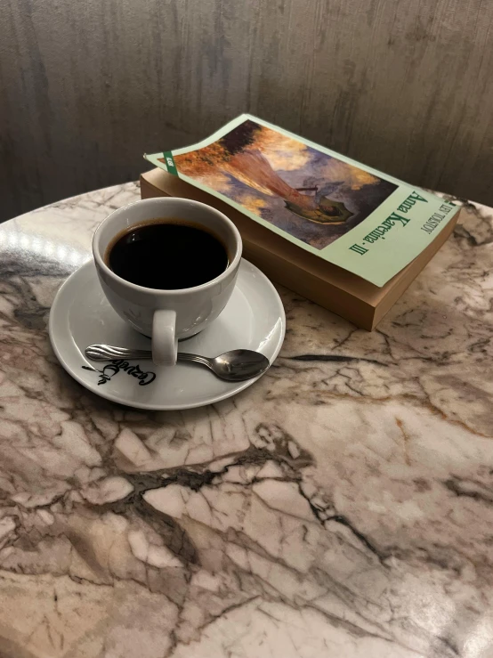 a cup of coffee and some kind of book on a table