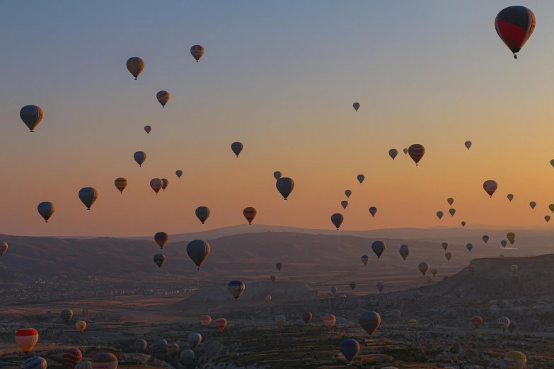 many balloons that are in the sky over the mountains