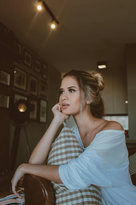 a woman sits in bed and stares off to the left