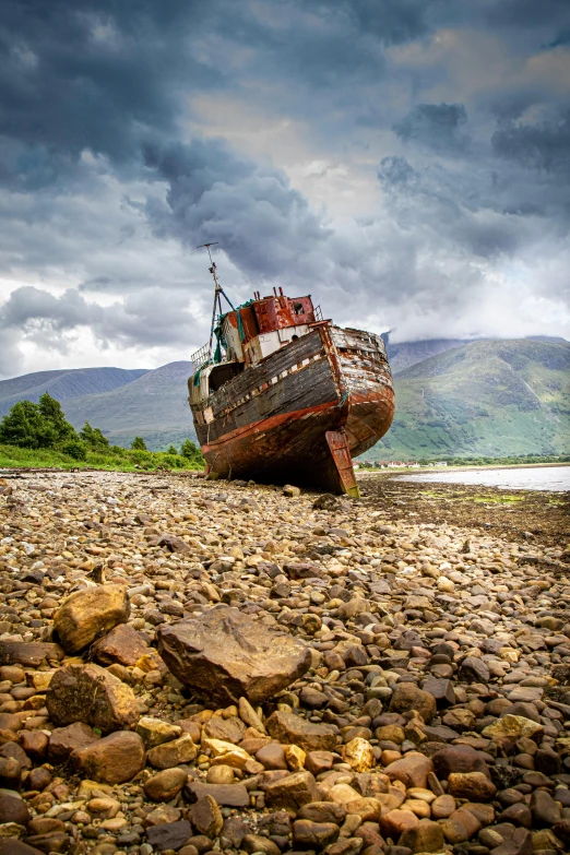 an old boat on dry land on rocks