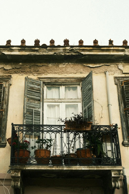a house with balcony plants and old windows