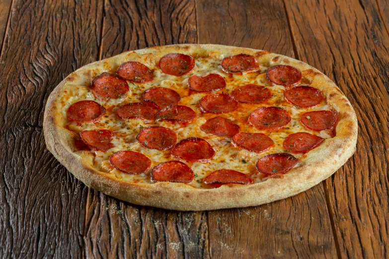 a whole pepperoni pizza on a wooden surface