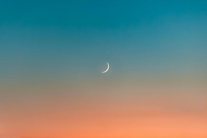 the moon is in the sky over a field