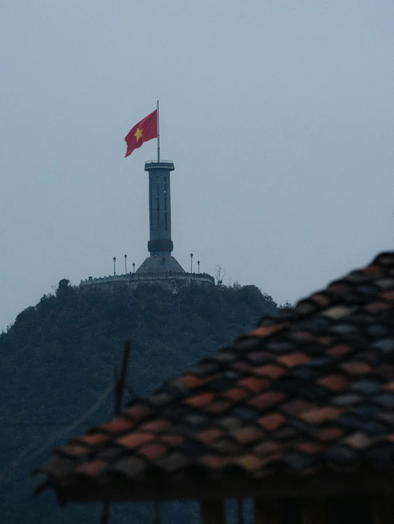 a tall red and white flag on top of a building