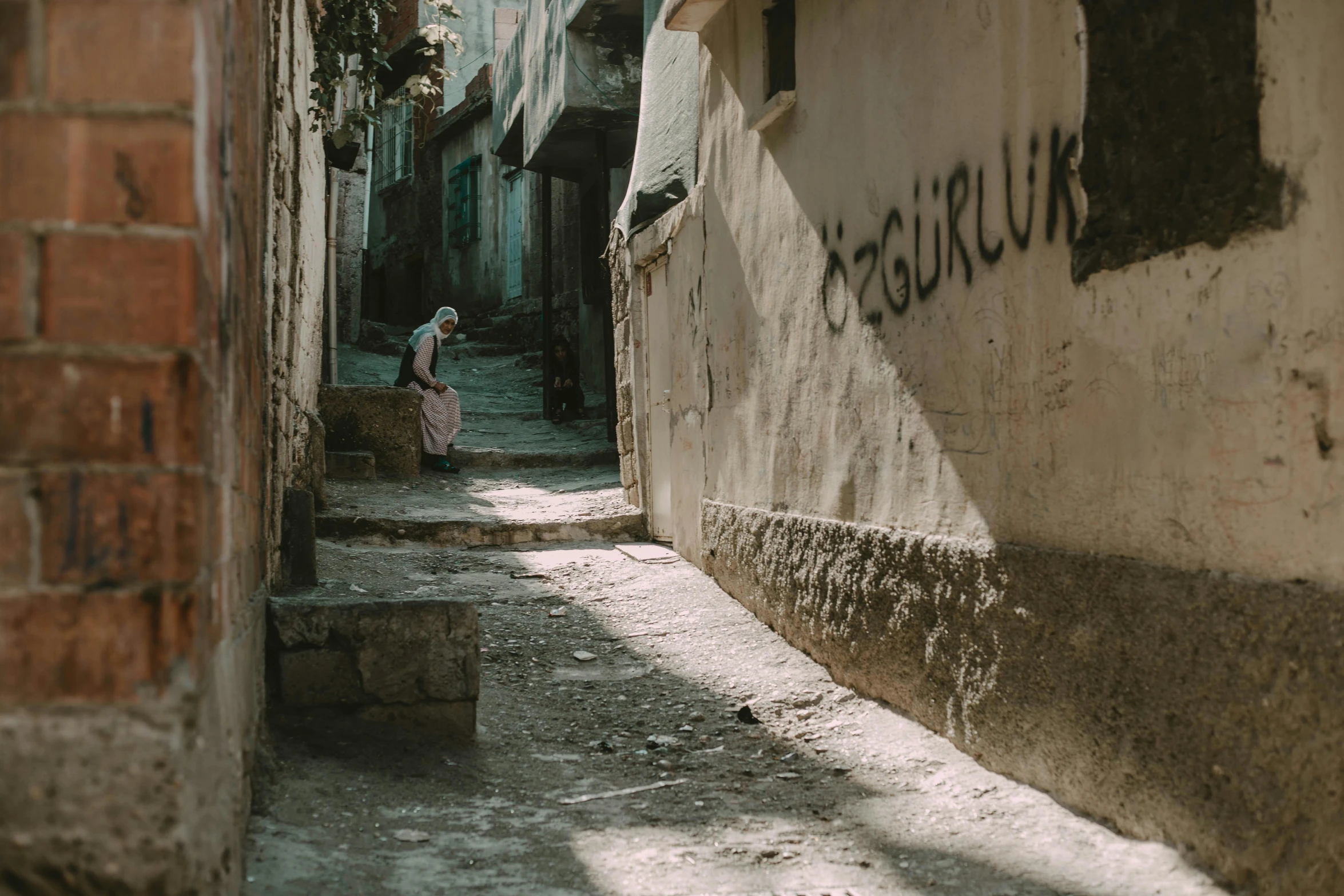 a woman in a long, pink dress is walking in an alleyway