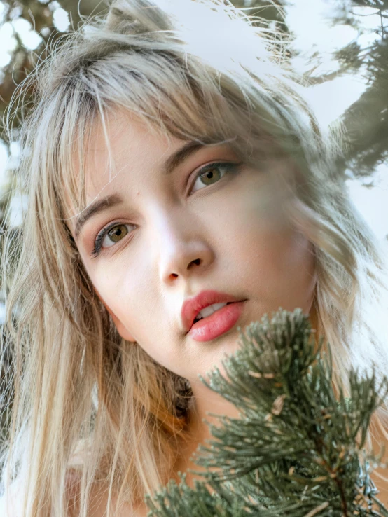 a young woman holds a green nch to her face