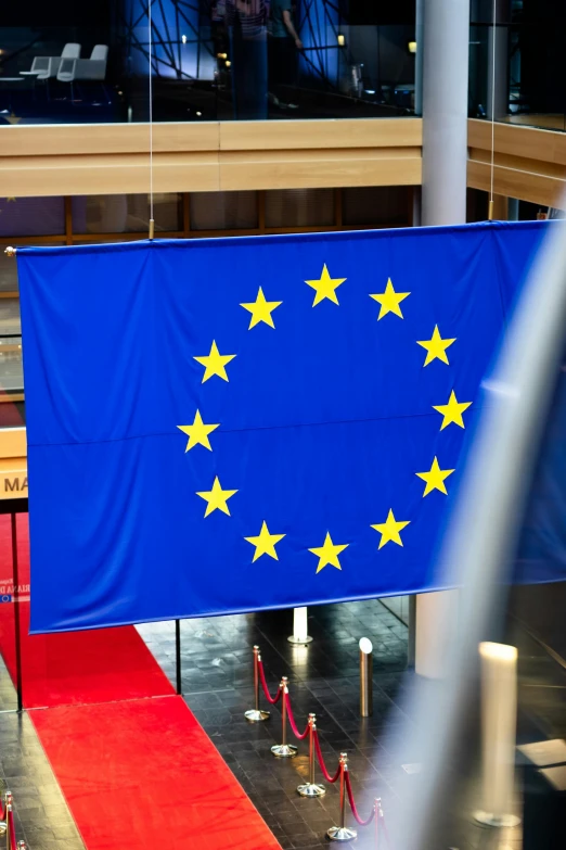 a blue european flag is hanging from poles