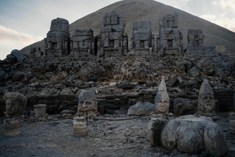 some rocks and buildings in front of a mountain