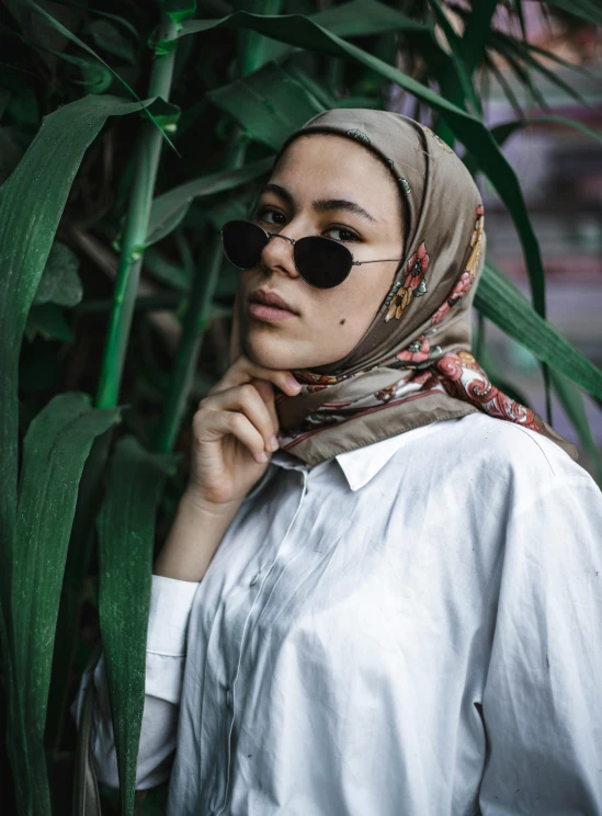 the woman is wearing a hijab by the palm trees