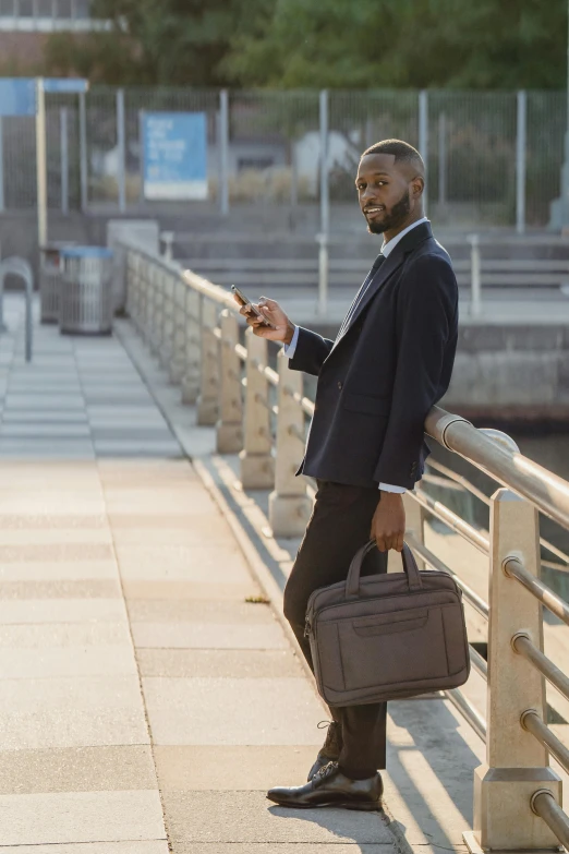 a man in a suit is holding his cellphone