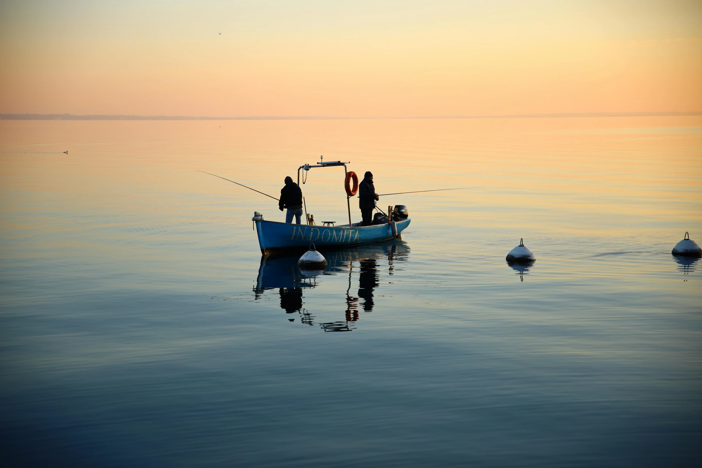 a small boat in the ocean with a couple of birds