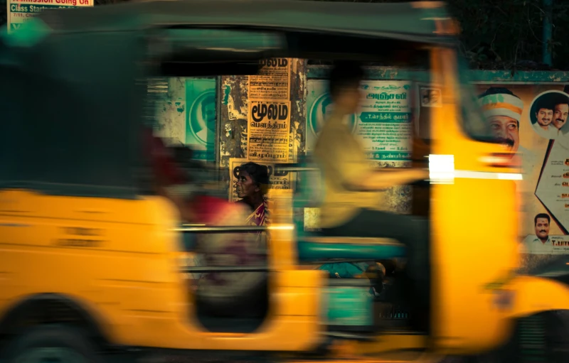 a yellow bus passing through an intersection on a busy street