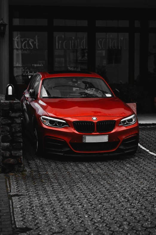 the red car is parked on the street in front of the building