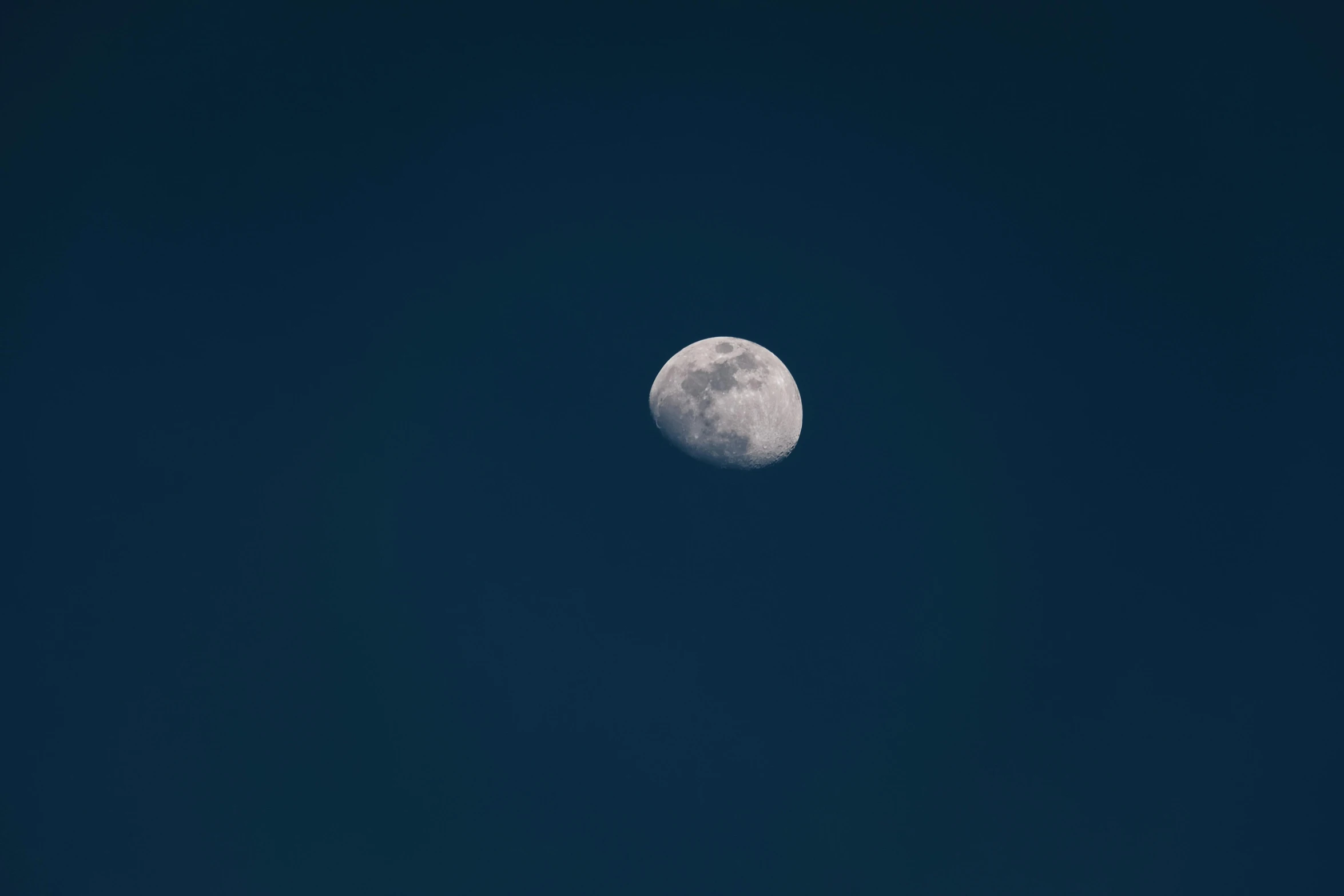 the moon seen through the dark blue sky