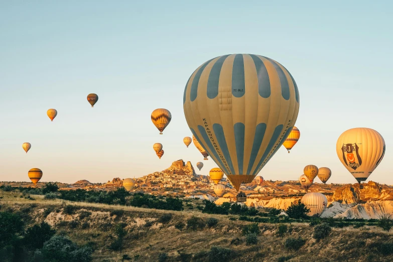 a field filled with lots of balloons in the sky