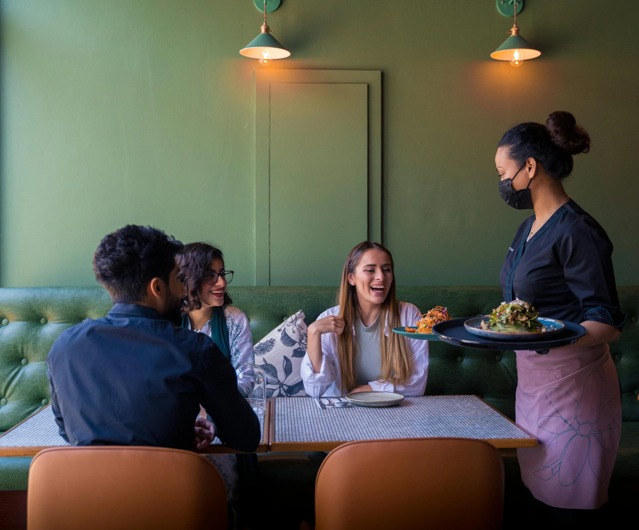 a group of people standing around a dining room table