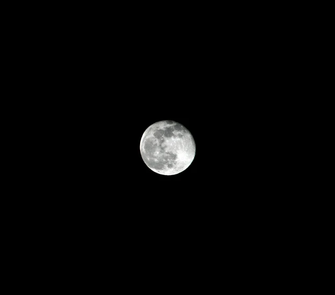 a full moon is seen on a dark night