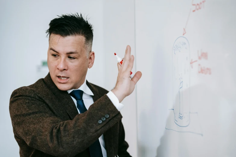 a man is using a marker to draw diagrams on a whiteboard