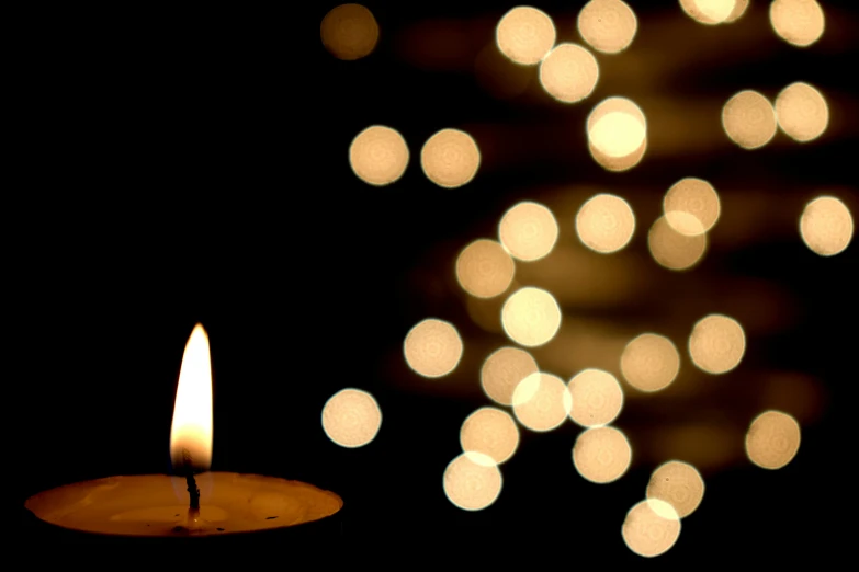 a lit candle is next to a blurry, deformed, dark background