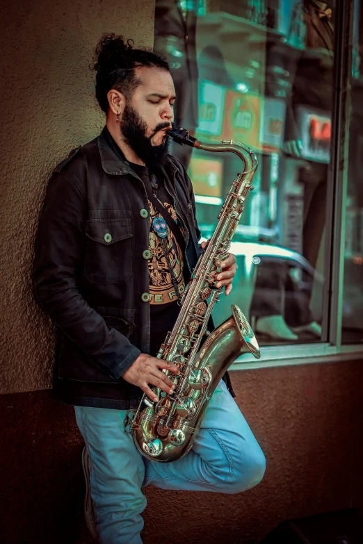 man in black jacket and blue jeans playing a saxophone