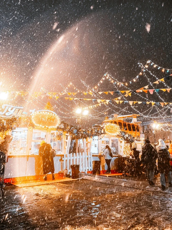 people gather beneath umbrellas in the rain on a rainy night