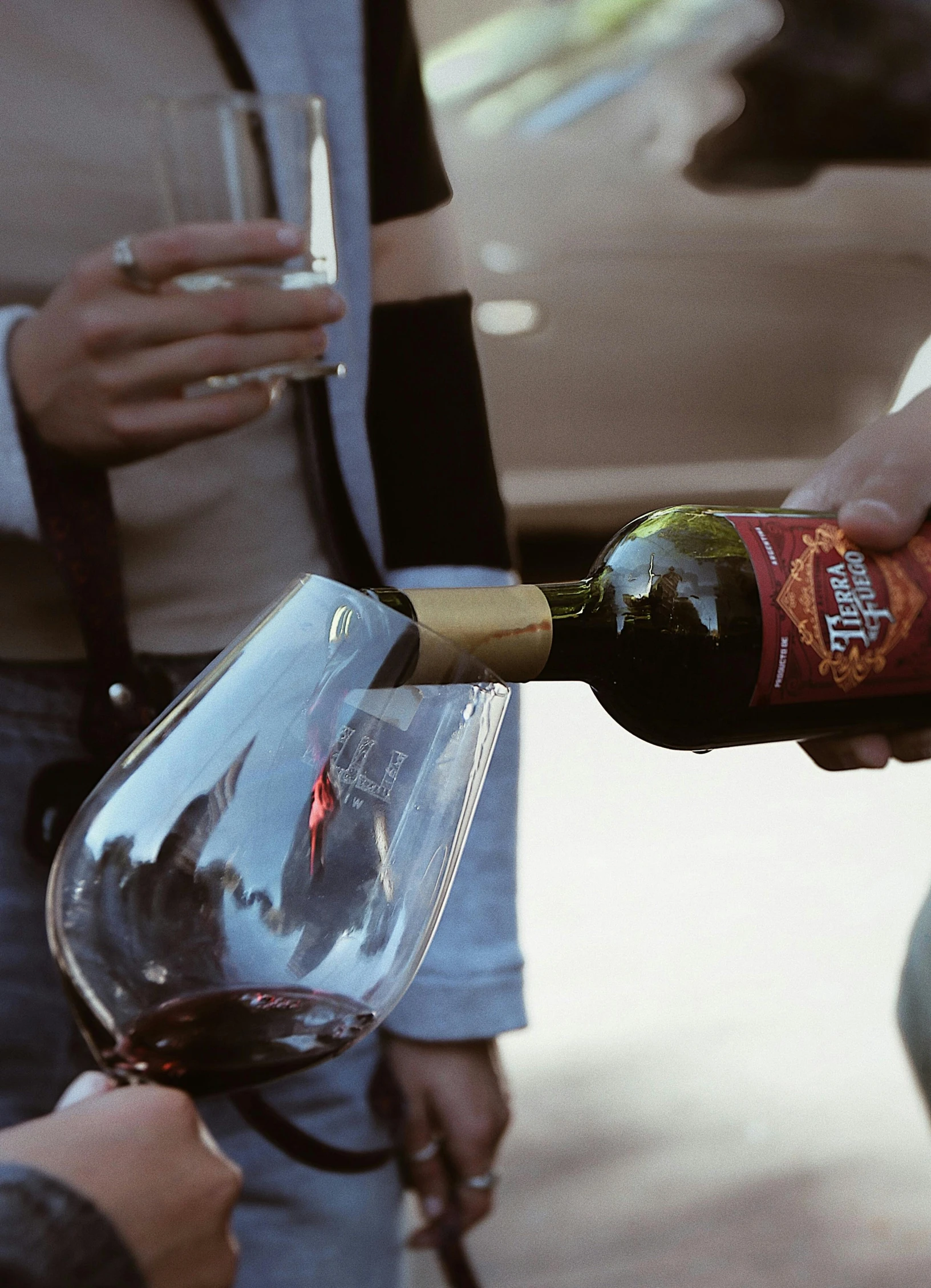 a person is pouring red wine into a glass