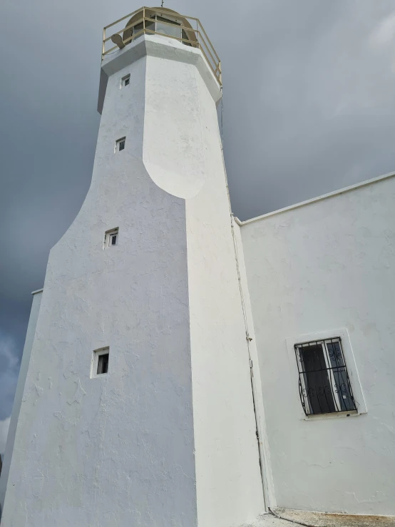 a tall white structure sits against a cloudy sky