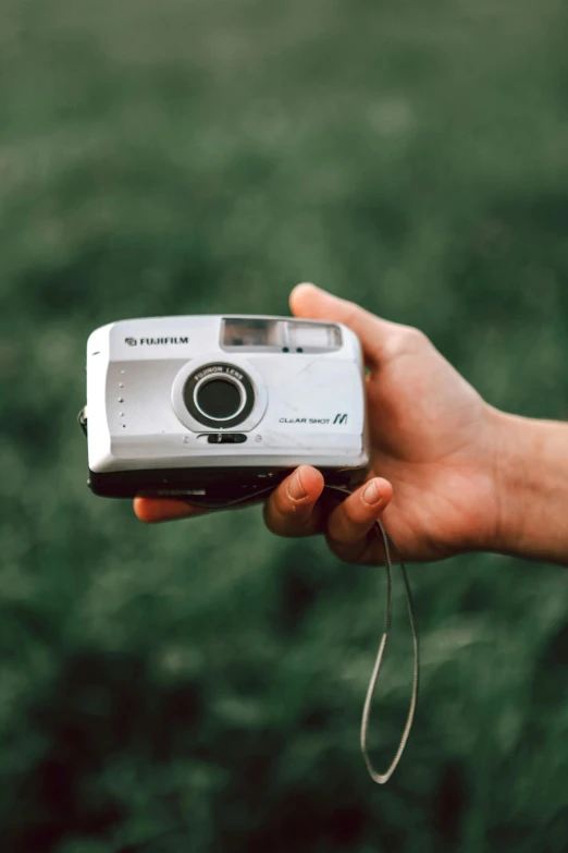 a person's hand holds a camera in their left palm