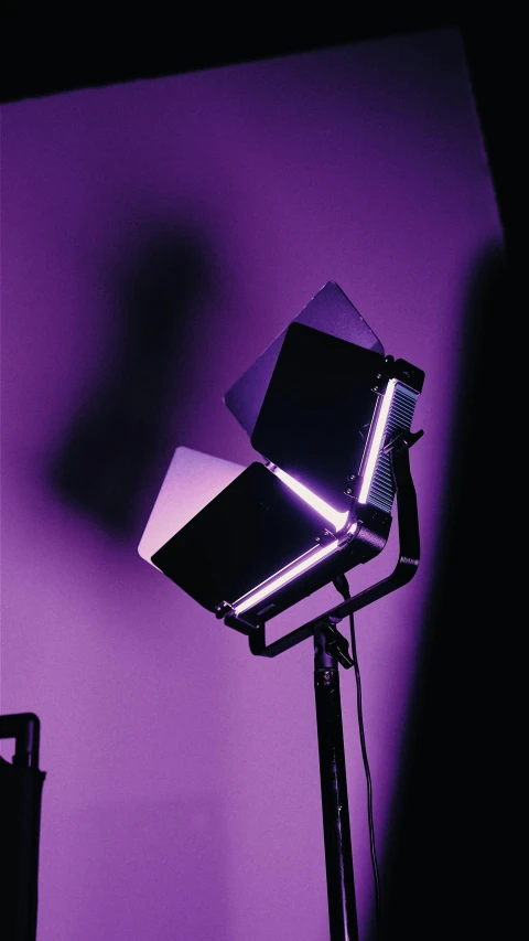 a studio light with the lighting on sitting against a purple wall