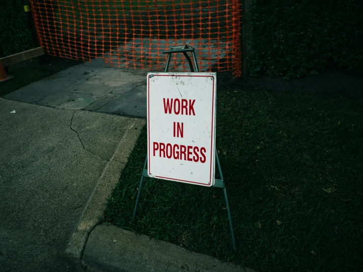 a work in progress sign sitting on the side of a road