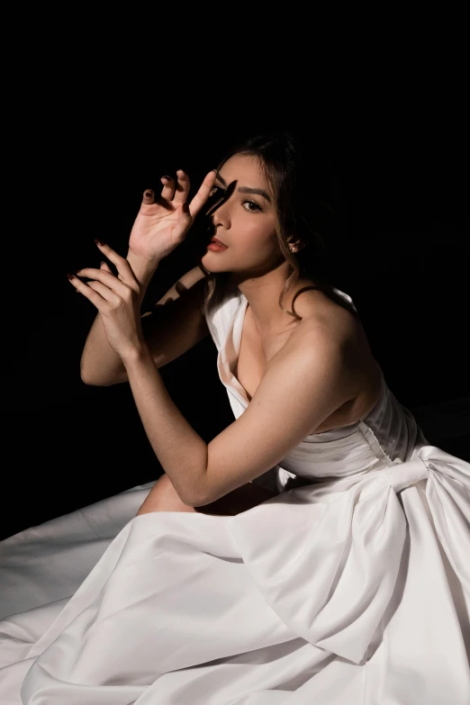 a woman sitting down in a white dress