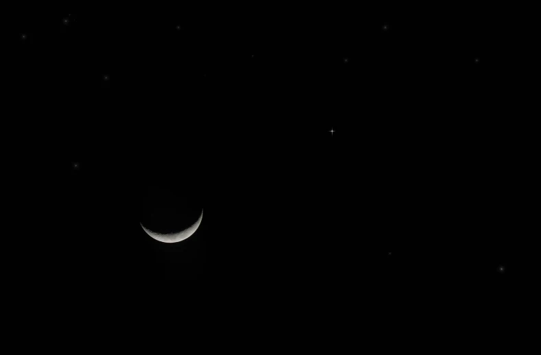 the moon is seen through the dark clouds