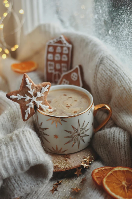 a cup of coffee with a christmas cookie in it