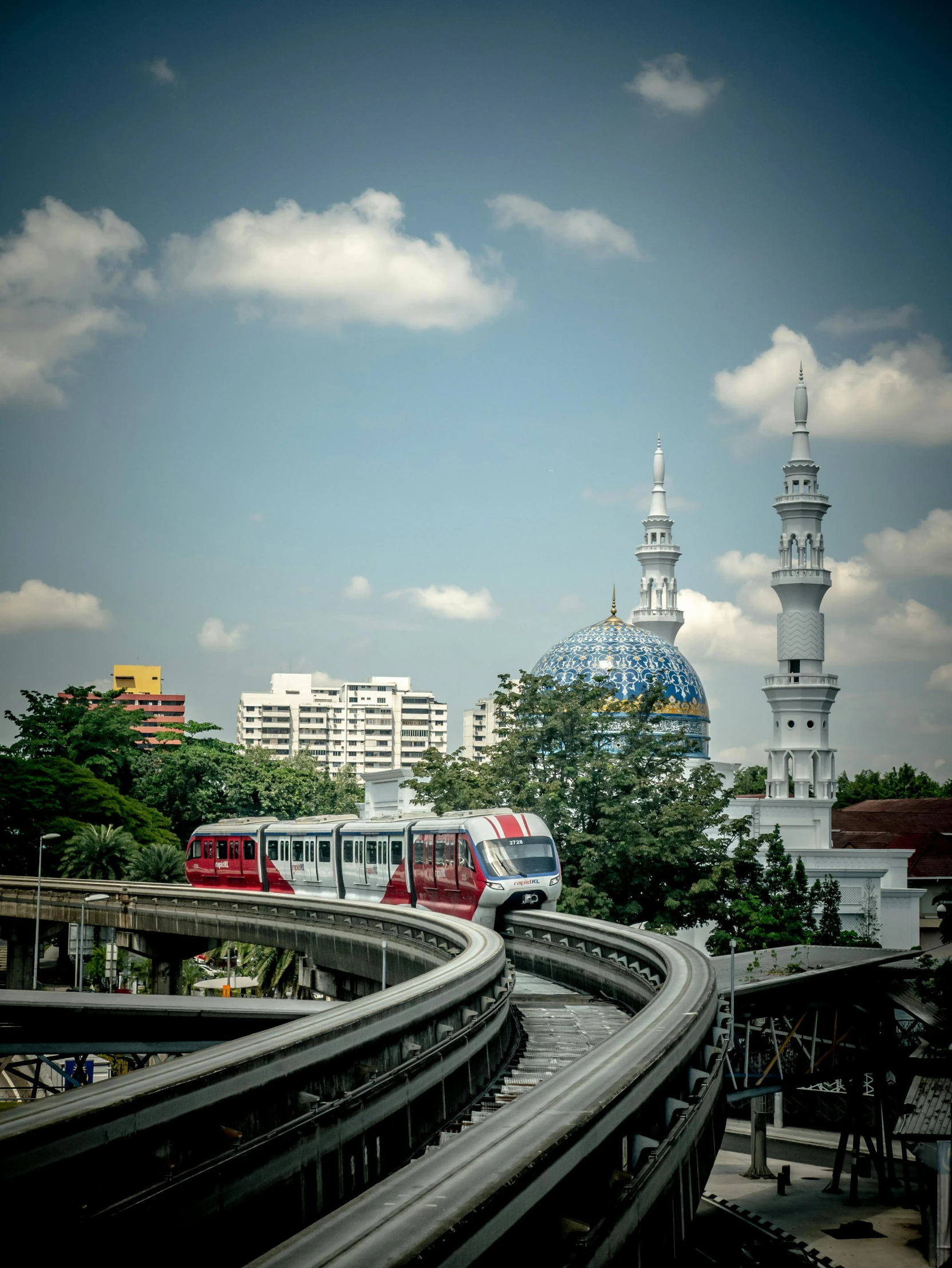 a train traveling on train tracks near tall buildings