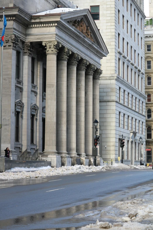 an old building with columns is shown along a street