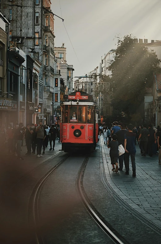 people gathered around a trolley going down the road