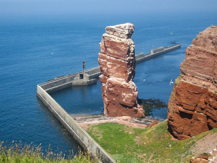 rocks stand near the ocean near an outdoor dock