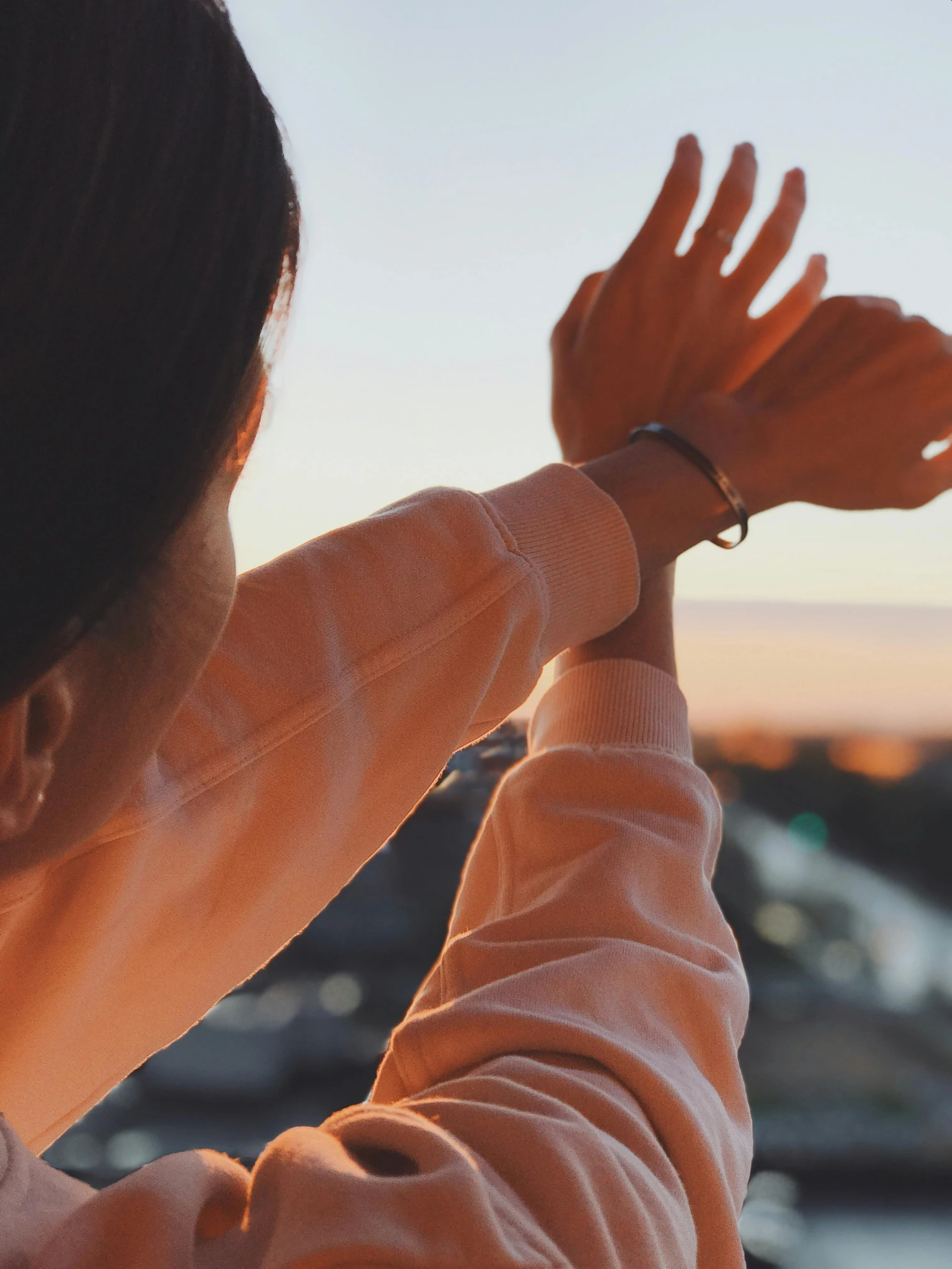 a woman with her hands in the air and a city