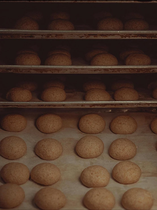 several shelves with doughnuts in them and baking