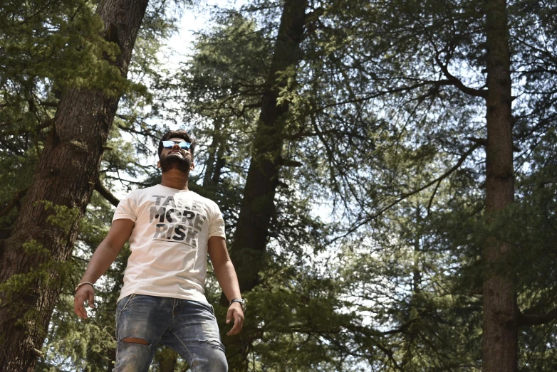 a young man is standing by some trees