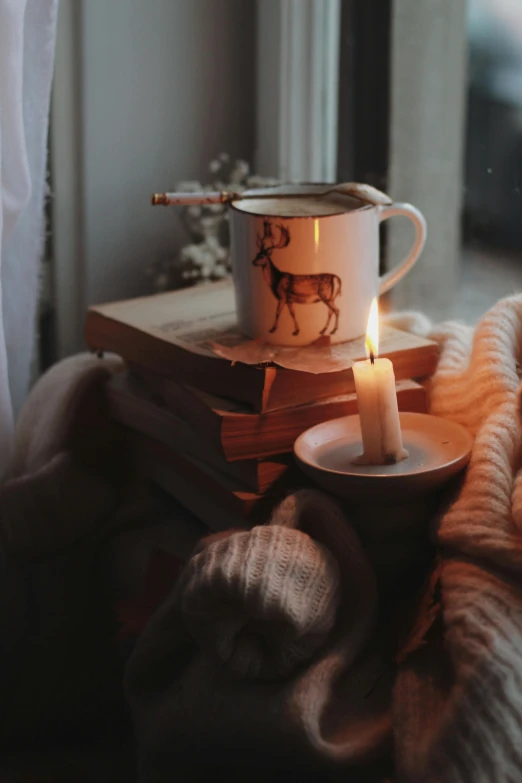 a tea cup and some books on a bed