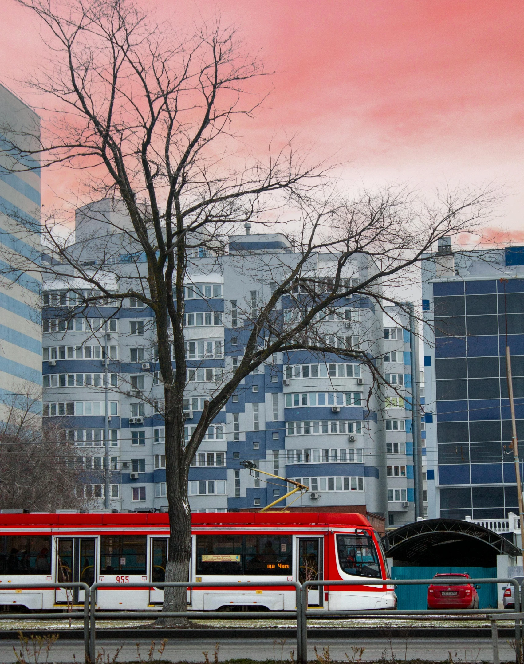 an electric train with some city buildings behind it