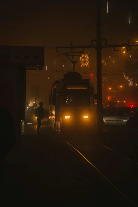 cars and people at an illuminated train station at night