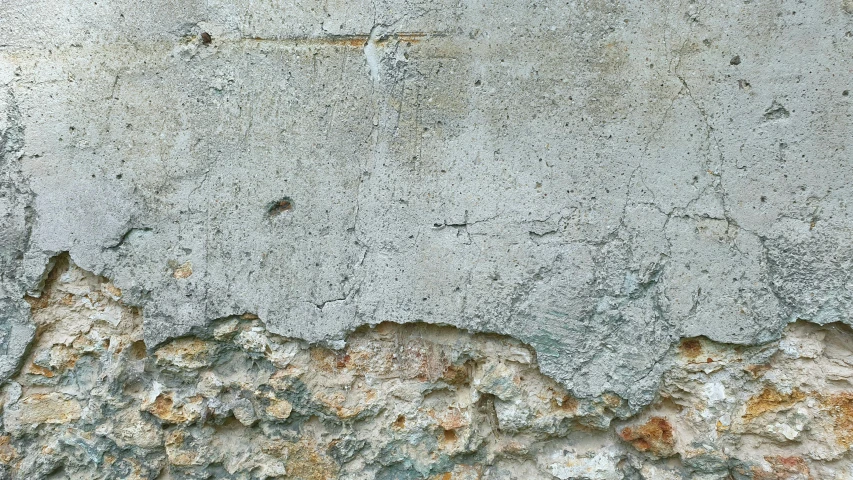 an old cement wall has s and rust on it