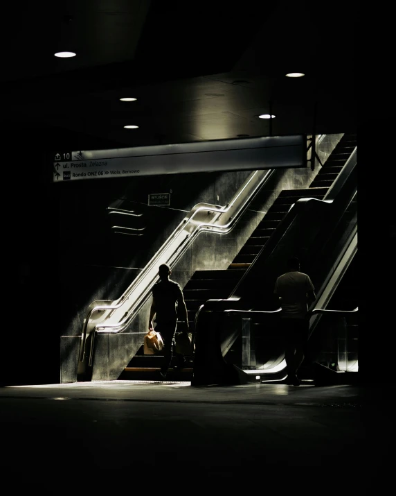 two people standing at an escalator near a dog
