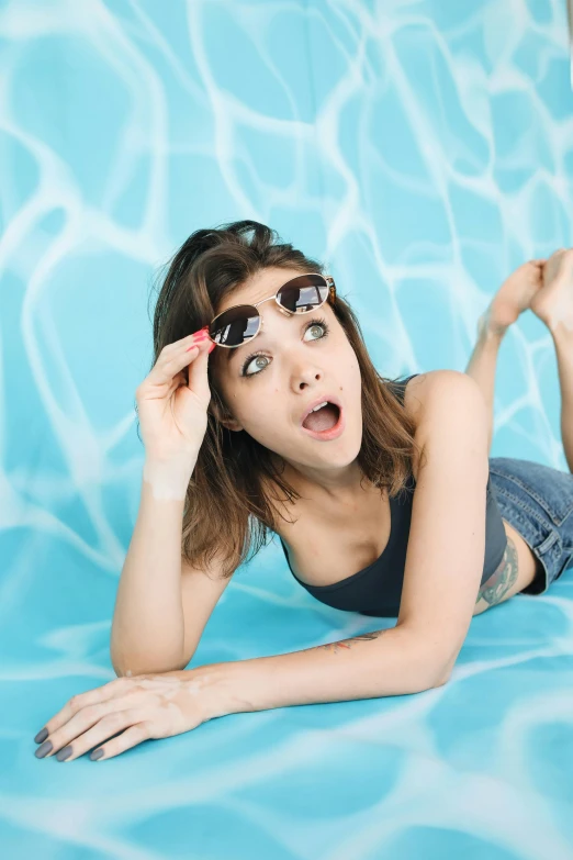 a girl laying down on top of a pool