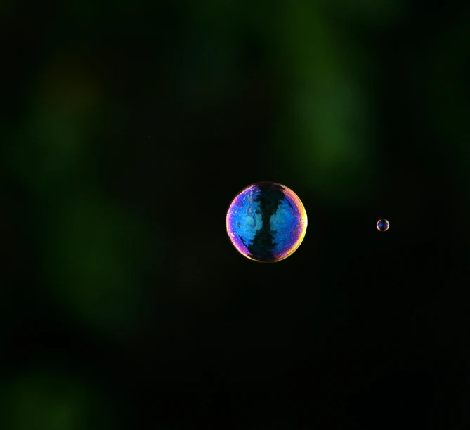 two bubbles one with water droplets and the other blue and green